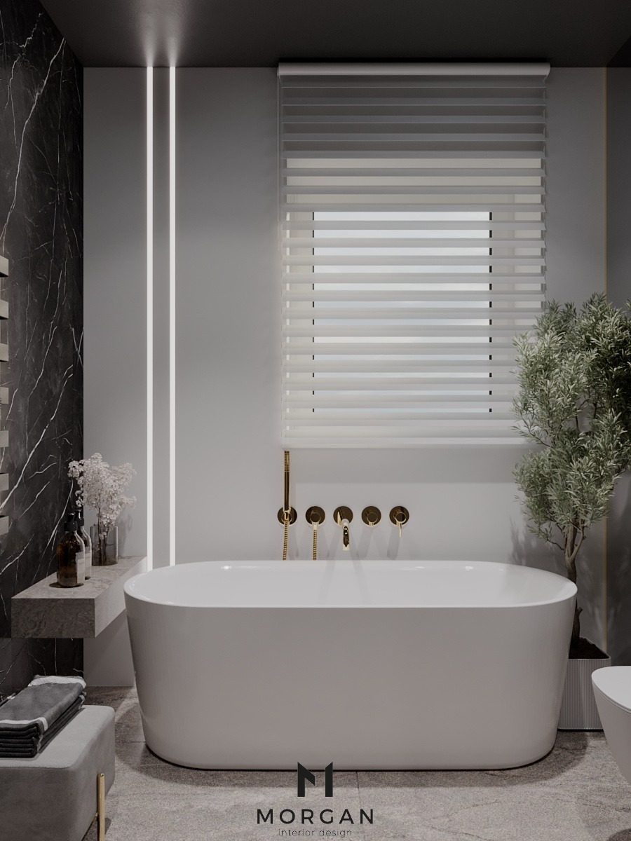 Elegancka łazienka w odcieniach szarości z białą, wolnostojącą wanną, złotą armaturą, marmurową ścianą i subtelnym oświetleniem LED.