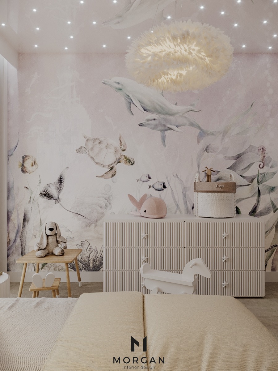Pokój dziecięcy z motywem morskim: tapeta z delfinami, komoda z gwiazdkami, lampa w kształcie chmury, stolik z krzesełkami i zabawki. Przytulne wnętrze.
