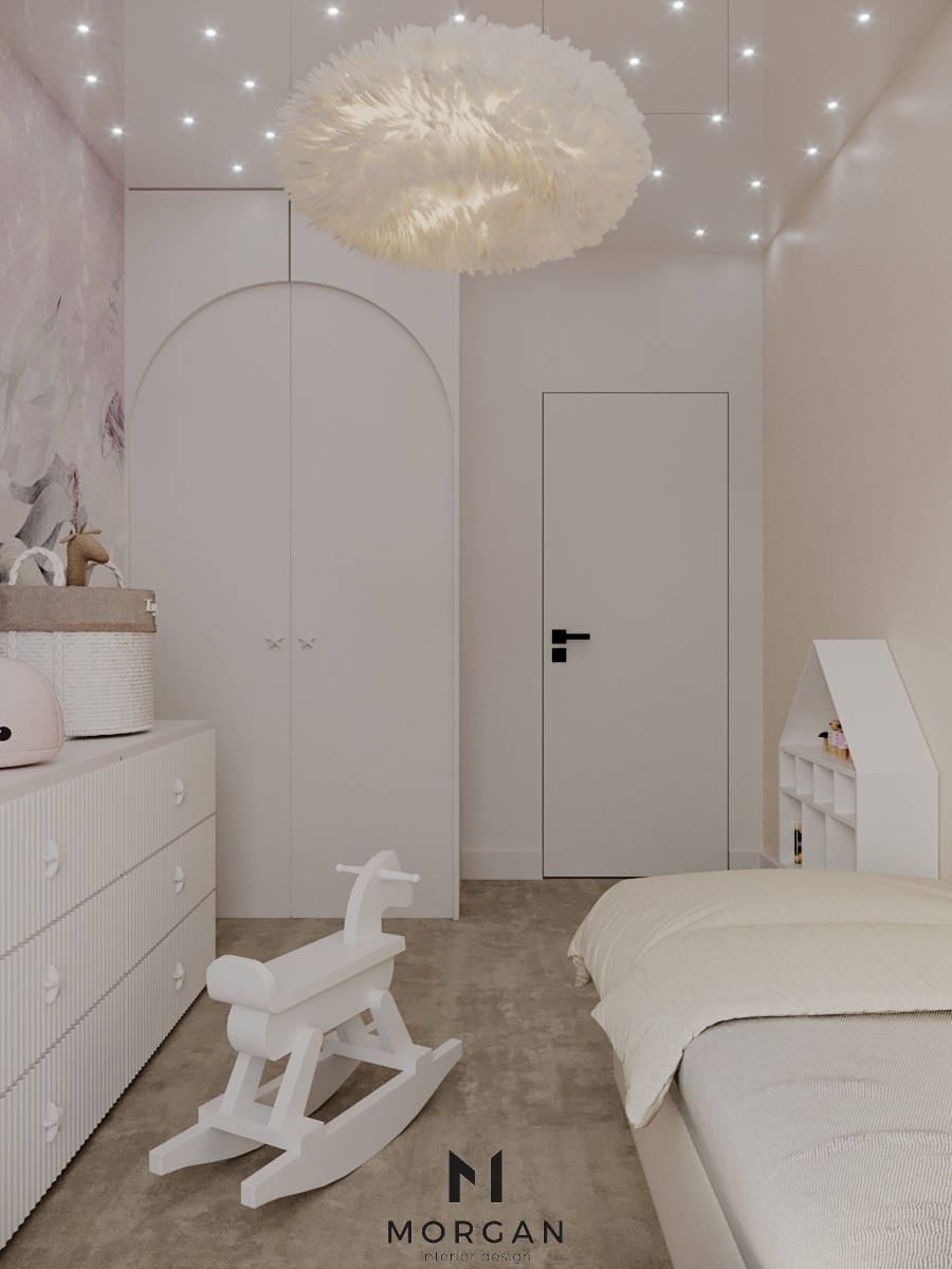 Jasny pokój dziecięcy z łóżkiem, komodą i białą, drewnianą zabawką konika na biegunach. Sufit zdobi dekoracyjna lampa i punkty świetlne.