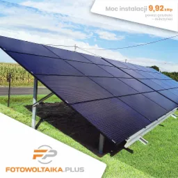 Instalacja paneli słonecznych o mocy 9,92 kWp na metalowej konstrukcji, z widocznym polem kukurydzy w tle i logotypem firmy w rogu.
