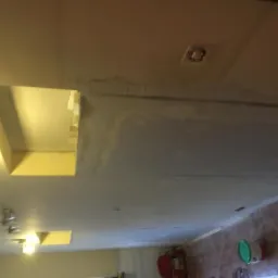 Szpachlowanie ściany z wnękami na oświetlenie w Gryficach, widoczne niedoskonałości przed dalszą obróbką.