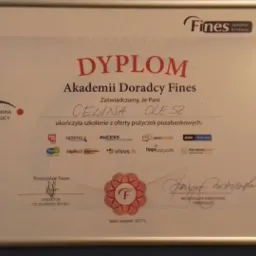 Dyplom Akademii Doradcy Fines dla Celiny Olesz za ukończenie szkolenia z oferty pożyczek pozabankowych, w ramce na niebieskiej ścianie.