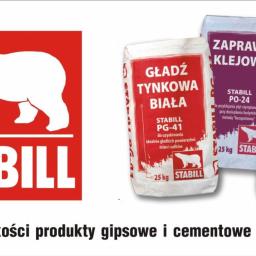 Zakład Ogólnobudowlany ZEN- BUD Zenon Kuźnik - Worki z zaprawą i gładzią tynkową firmy Stabil, z logo z białym niedźwiedziem polarnym na czerwonym tle, obok hasło reklamowe o najwyższej jakości produktach gipsowych i cementowych.