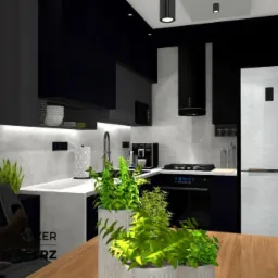 Wizualizacja nowoczesnej kuchni w odcieniach czerni i szarości z akcentami zieleni, drewniany stół na pierwszym planie, na ścianie wiszą oprawione grafiki i rysunki, obok lodówki tablica kredowa...