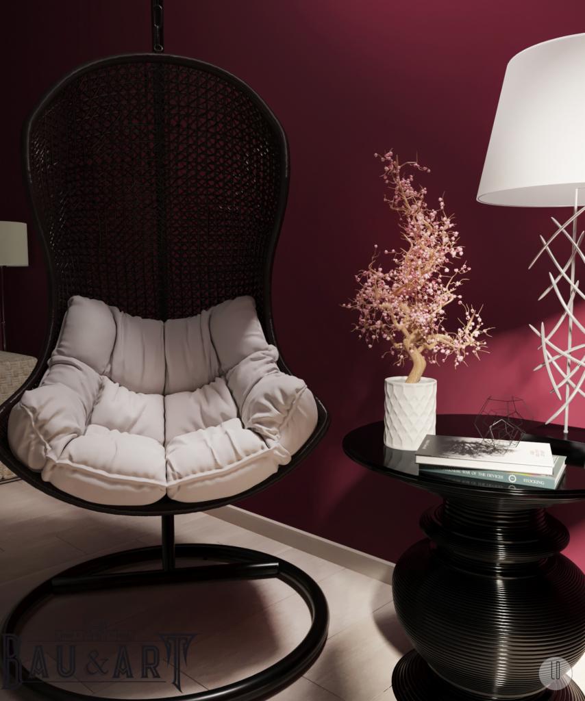 Wnętrze z wiszącym fotelem z rattanu z poduszką, okrągłym stolikiem z książkami i dekoracyjną lampą na tle bordowej ściany.