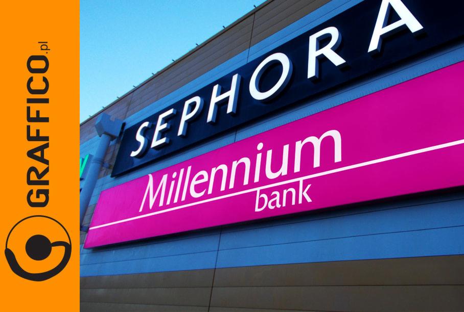 Zewnętrzne szyldy reklamowe Sephora i Millennium Bank na elewacji budynku, z logo firmy na pierwszym planie po lewej stronie.