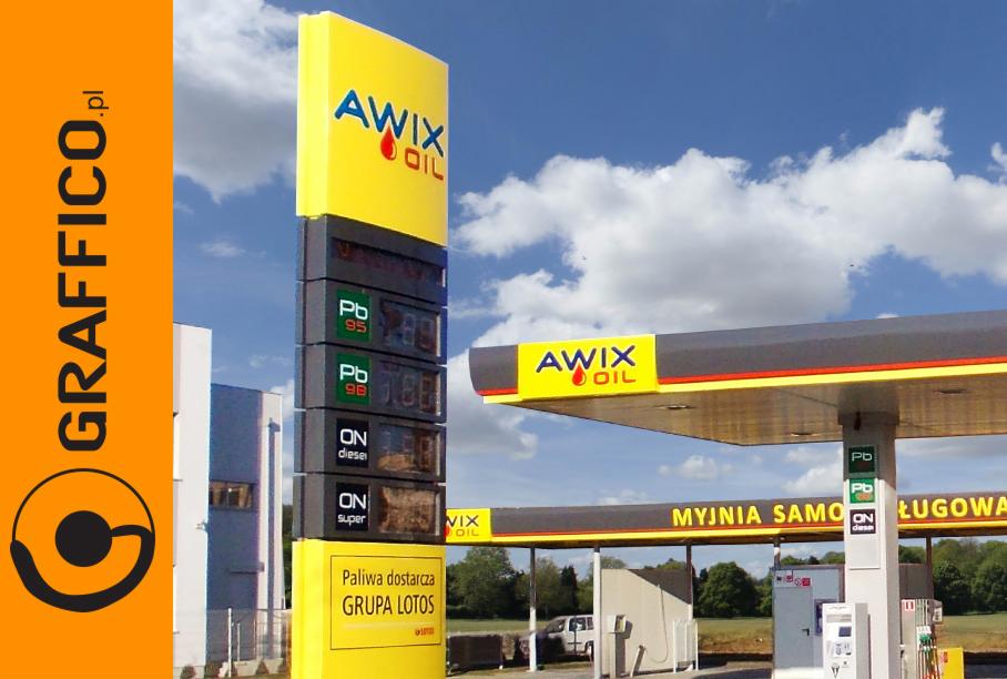 Pylon cenowy paliw z logo Awix Oil na stacji benzynowej Grupy Lotos, widoczne ceny Pb95, Pb98, ON diesel i ON super, w tle błękitne niebo z chmurami.