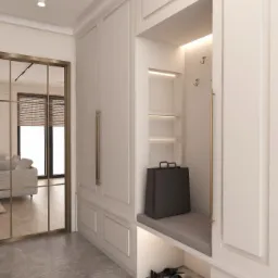 Elegancki przedpokój w jasnych barwach z zabudową meblową: szafa z siedziskiem, haczyki na ścianie, torba na siedzisku, robot sprzątający i buty pod spodem, lustrzane drzwi przesuwne z widokiem...