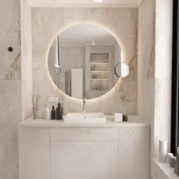 Nowoczesna łazienka z marmurowymi ścianami, okrągłym lustrem z podświetleniem LED, białą szafką pod umywalką i minimalistycznymi akcesoriami.