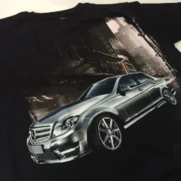 Czarna koszulka z nadrukiem przedstawiającym srebrny samochód Mercedes C-Class na tle panoramy miasta.