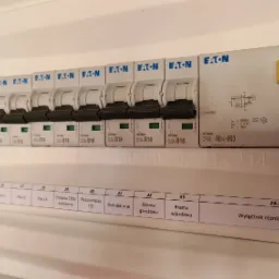 Rozdzielnica elektryczna z wyłącznikami nadprądowymi Eaton xClear CLS6-B16 i wyłącznikiem różnicowoprądowym CF16-40/4/003, z opisami obwodów na naklejkach.