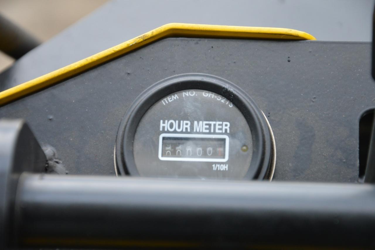 Zbliżenie licznika motogodzin wskazującego 56000 godzin pracy na panelu sterowania maszyny budowlanej z żółtymi elementami wykończeniowymi.