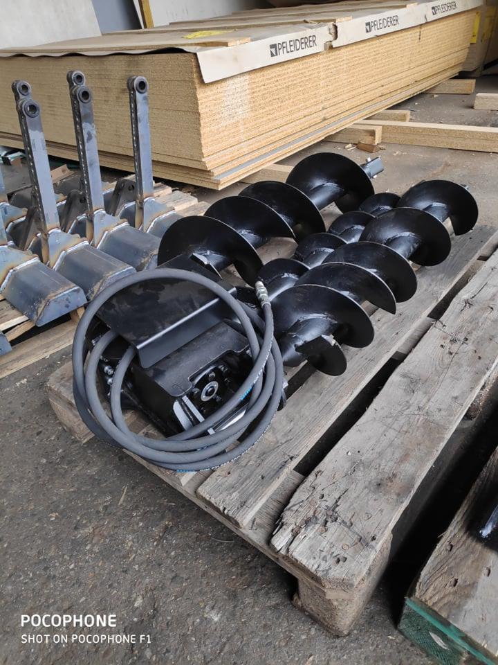 Wiertnice glebowe, osprzęt do maszyn budowlanych na palecie, w tle płyty drewniane.