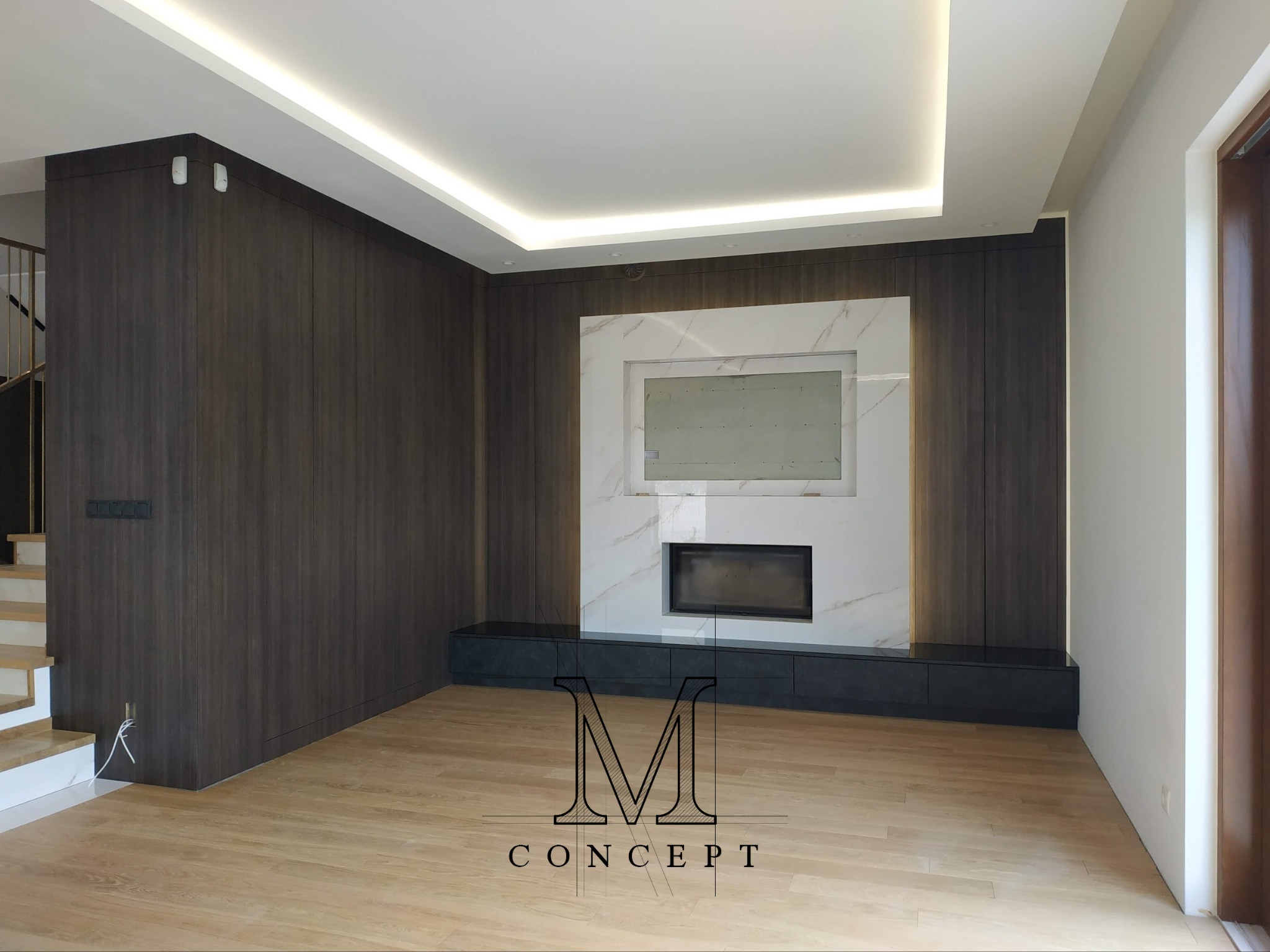 Minimalistyczny salon z drewnianą boazerią, marmurowym kominkiem i podświetlanym sufitem. Widoczne schody i nowoczesne oświetlenie.