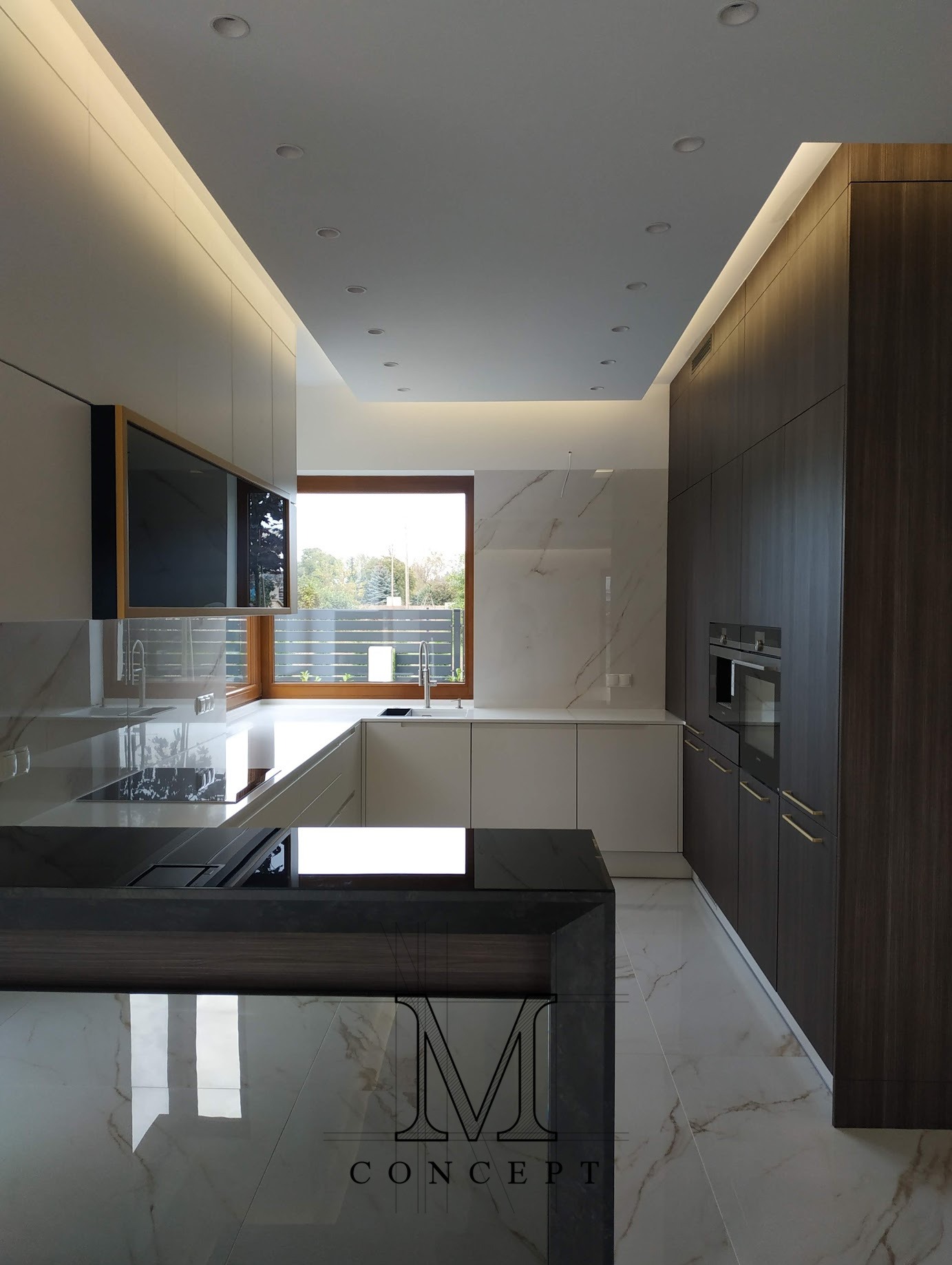 Nowoczesna kuchnia: białe i grafitowe szafki, marmurowe blaty i podłoga, okno z widokiem na zieleń. Oświetlenie sufitowe i listwy LED. Minimalistyczny design.