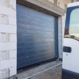 P.H.U. Para- door Łukasz Zadański - Montaż segmentowej bramy garażowej w surowym stanie budynku, widoczny fragment białego furgonetki obok.