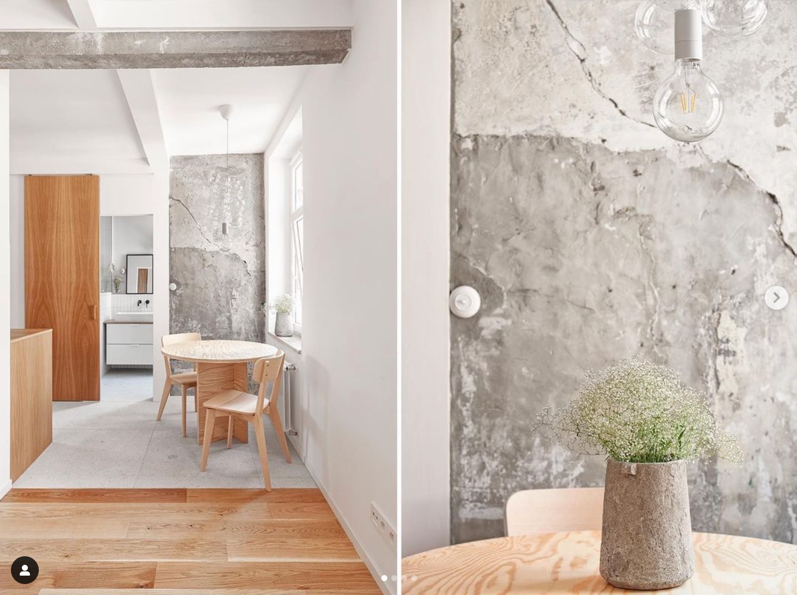 Jasne wnętrze mieszkania z drewnianym stołem i krzesłami, surową betonową ścianą i minimalistycznym oświetleniem.