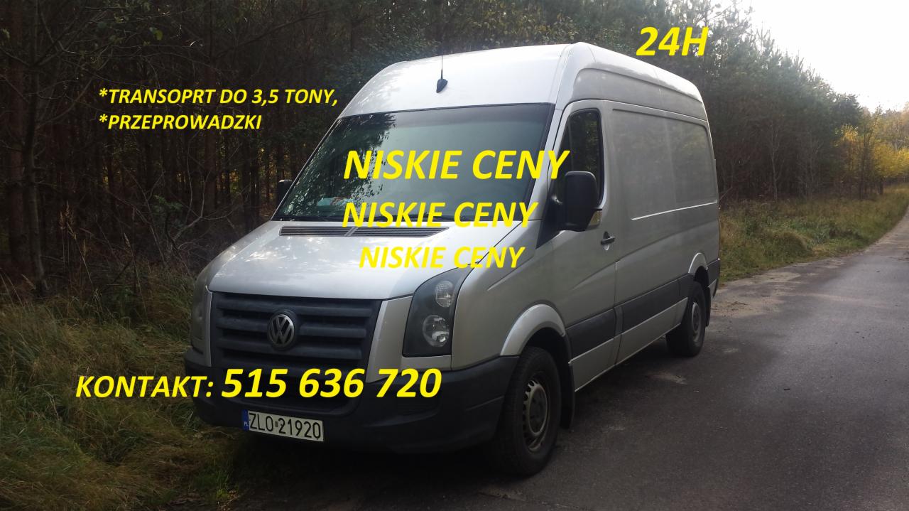 Srebrny bus dostawczy marki Volkswagen Crafter z żółtymi napisami reklamowymi 'NISKIE CENY', 'KONTAKT: 515 636 720' i '24H' zaparkowany na poboczu drogi w pobliżu lasu.