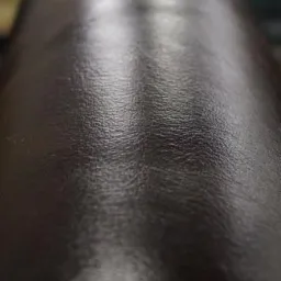 Zbliżenie na ciemny, błyszczący blat kamienny z widoczną fakturą i refleksami światła.