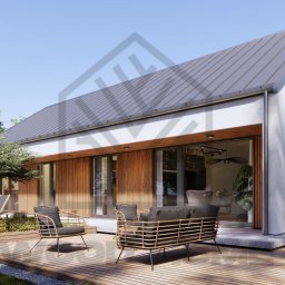 WOOD- HOME SL&S AG Sp. z o.o. - Nowoczesny dom z białymi ścianami i szarym dachem, z tarasem z drewnianych desek i meblami ogrodowymi w otoczeniu zieleni. Widok z zewnątrz w słoneczny dzień.