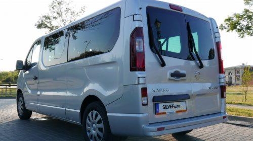Srebrny bus Opel Vivaro z przyciemnianymi szybami, widok z tyłu, tablica rejestracyjna z nazwą firmy Silver Auto.