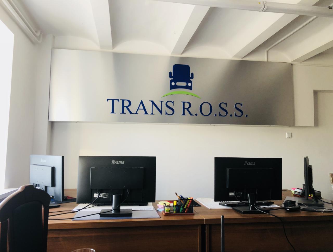 Biuro firmy transportowej z logo TRANS R.O.S.S. nad stanowiskami pracy z monitorami Iiyama.