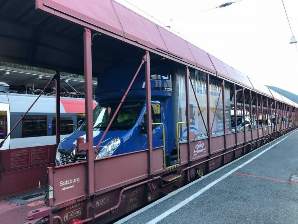Niebieski bus Renault w wagonie kolejowym z napisem Salzburg, prawdopodobnie transportowany do innego kraju.