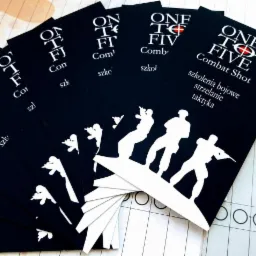 Stos czarnych kart z białym tekstem 'ONE TO FIVE Combat Shot: szkolenia bojowe, strzelanie, taktyka' i sylwetkami żołnierzy z bronią, ułożonych wachlarzowo na tle planszy do gry.