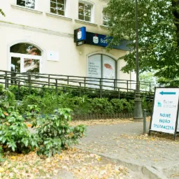 Wejście do biura tłumaczeń Better Horizons z podjazdem dla niepełnosprawnych, widoczny szyld reklamowy z napisem 'Nowe biuro tłumaczeń'.