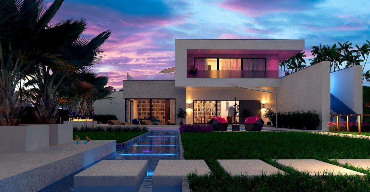 Nowoczesny dom z płaskim dachem i oświetleniem LED, widok na ogród z kaskadą wodną i palmami o zmierzchu.