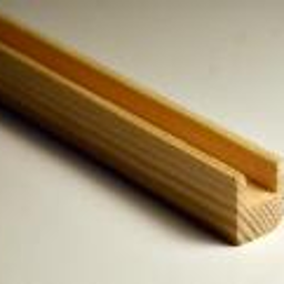 Zakład Stolarski Leszek Jabcoń - Profilowana listwa z jasnego drewna iglastego, widoczny przekrój w kształcie litery U, oświetlenie naturalne, lekki cień.