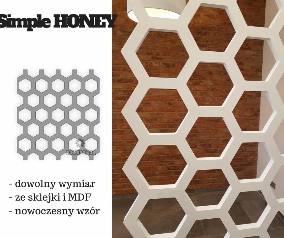 Biała, ażurowa ścianka działowa z motywem plastra miodu na tle ceglanej ściany, z widocznym logo i informacjami o produkcie.
