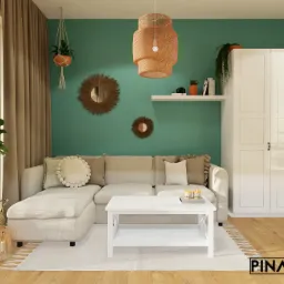 Jasne wnętrze salonu w stylu boho z turkusową ścianą, rattanowym żyrandolem, lustrami w ramie z trawy morskiej, narożną sofą, białym stolikiem kawowym i trzydrzwiową szafą.