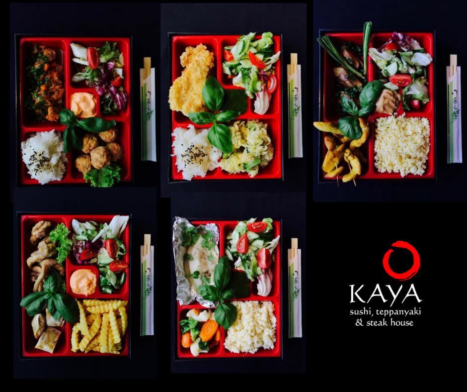 Zestawienia dań w czerwonych bento boxach na czarnym tle, widoczne różnorodne potrawy: ryż, sałatki, smażone mięso, warzywa, frytki oraz pałeczki, uzupełnione listkami bazylii, obok logo restauracji.