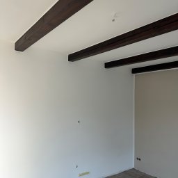 Ściany i sufity wyszpachlowane, wytapetowane i pomalowane, a belki zabezpieczone 