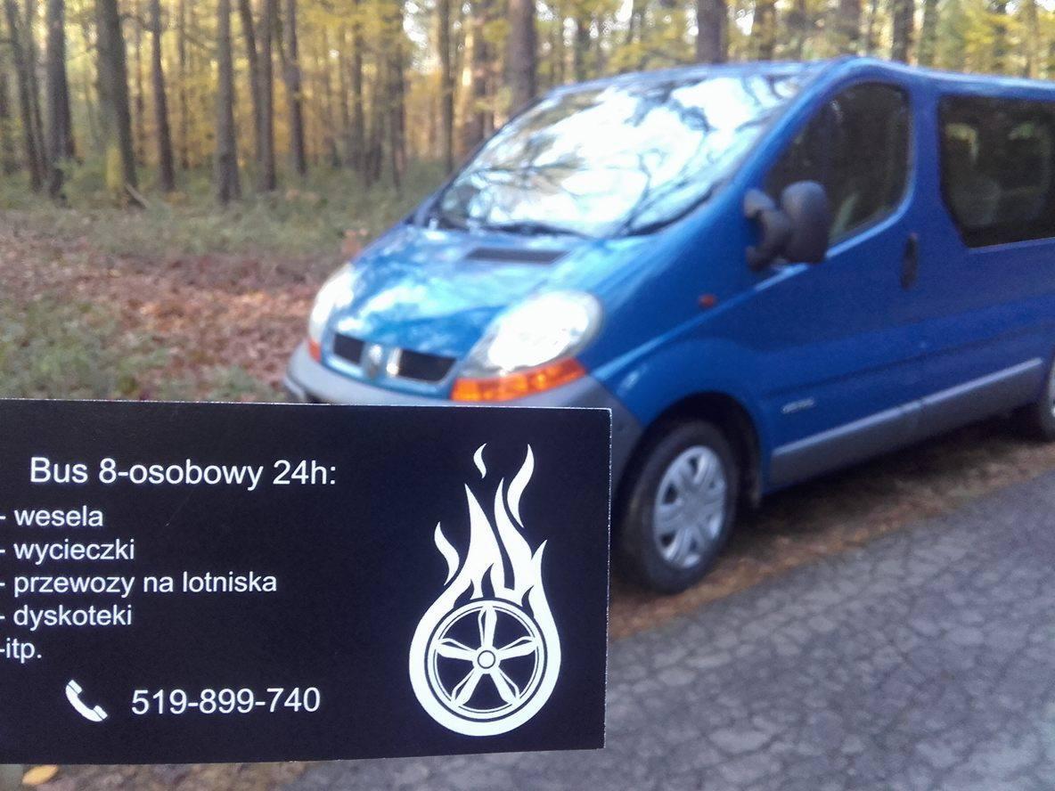 Niebieski bus 8-osobowy na tle drzew, z wizytówką reklamującą przewozy na wesela, wycieczki, lotniska i dyskoteki, z numerem telefonu.