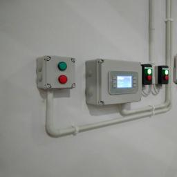 Everest 24 Jacek Cichocki Andrzej Tuczyński s.c. - Panel sterowania z wyświetlaczem i przyciskami na ścianie, z widocznymi rurami instalacyjnymi.