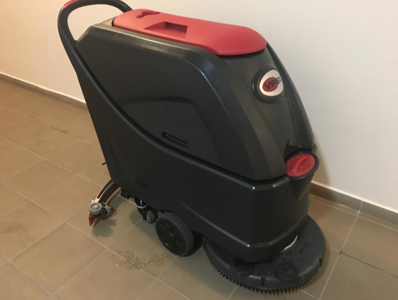 Profesjonalna, samojezdna maszyna czyszcząca marki Viper, z czerwonymi akcentami, stojąca na brązowych płytkach podłogowych w jasnym pomieszczeniu.