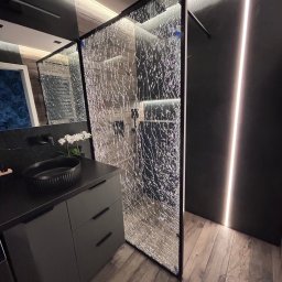 Fachowiec - Nowoczesna łazienka z kabiną prysznicową ze szkła ornamentowego, czarną armaturą i oświetleniem LED. Umywalka nablatowa na szafce w kolorze grafitowym.