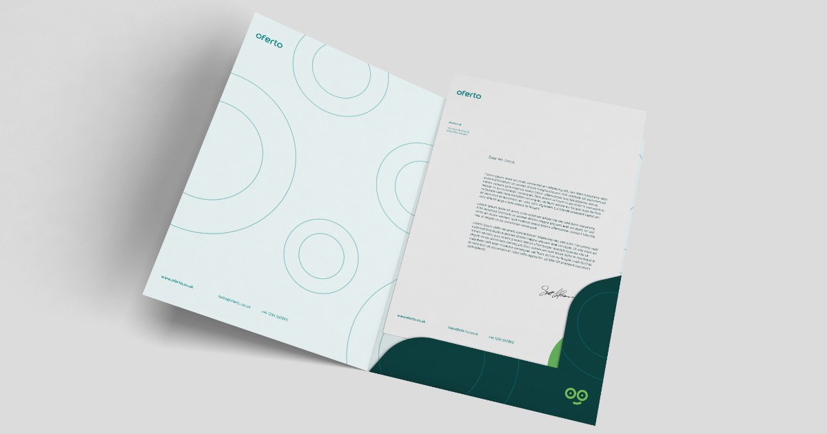 Otwarta firmowa teczka z dokumentami, z minimalistycznym wzorem kół na okładce i zielonym akcentem w dolnej części, leżąca na jasnym tle.