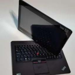 Czarny laptop Lenovo ThinkPad z ekranem dotykowym ustawionym pod kątem, widoczna klawiatura i touchpad