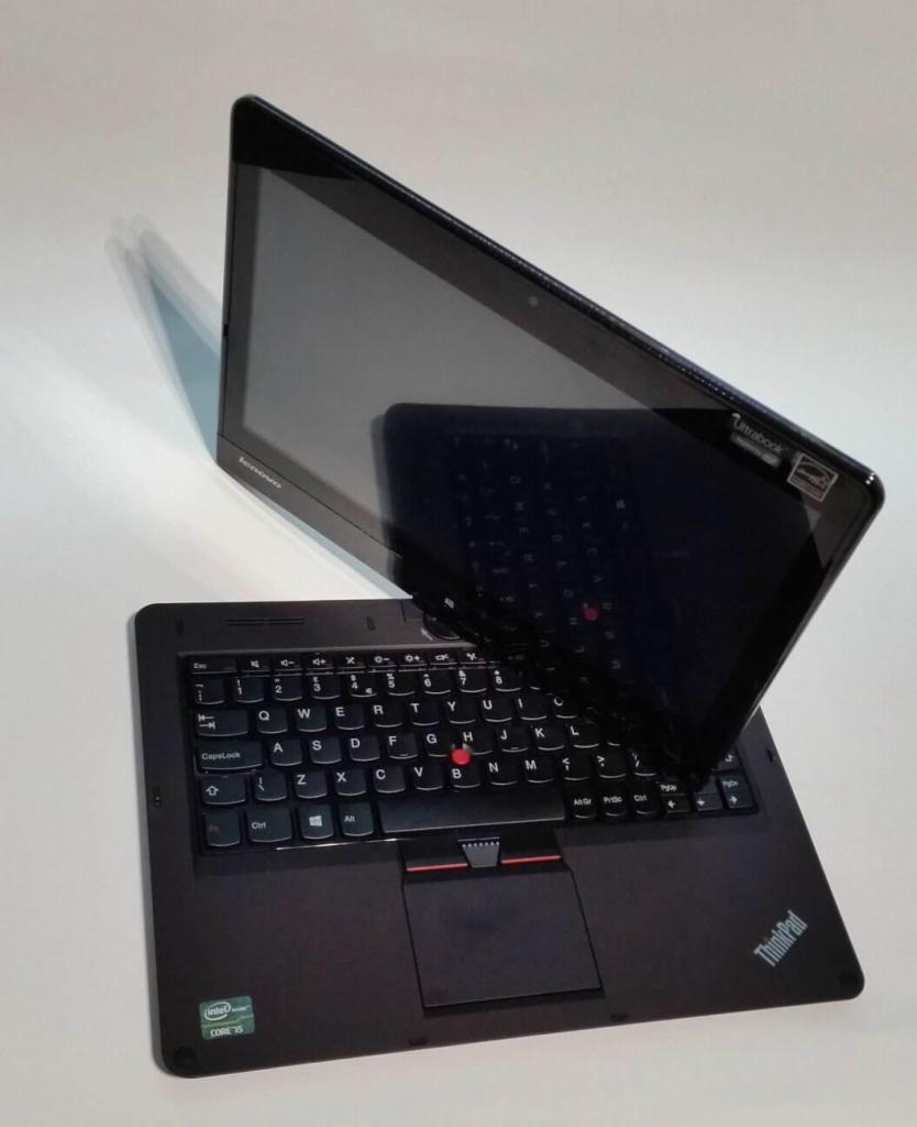 Czarny laptop Lenovo ThinkPad z ekranem dotykowym ustawionym pod kątem, widoczna klawiatura i touchpad