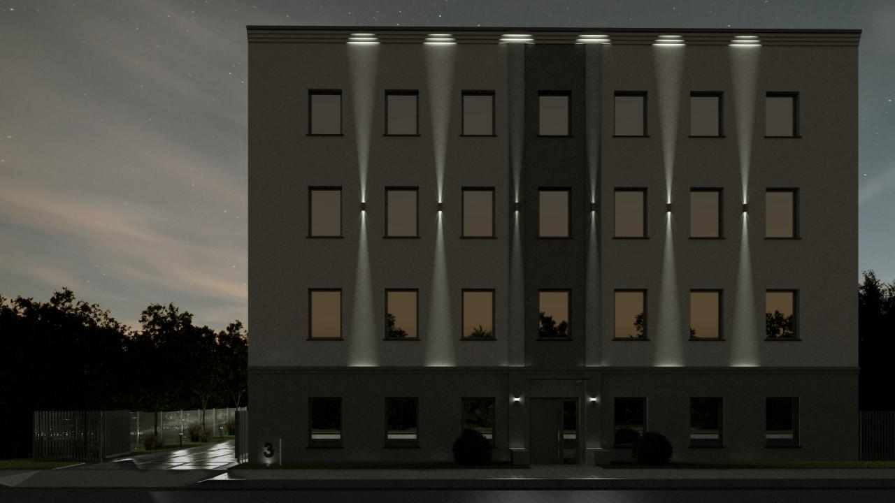 Elewacja trzypiętrowego budynku z oświetleniem zewnętrznym w nocy, widoczne gwiazdy na niebie, oświetlony chodnik.