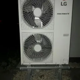 Biała pompa ciepła LG Therma V na metalowej konstrukcji wsporczej, zainstalowana na żwirowym podłożu.