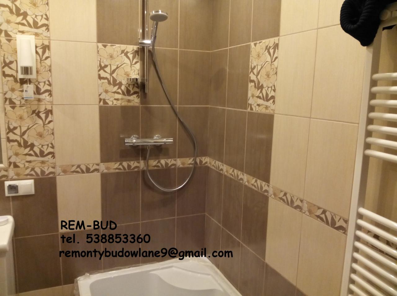 Wykończona łazienka z brązowo-beżowymi płytkami z motywem kwiatowym, chromowaną armaturą prysznicową i grzejnikiem drabinkowym, widoczny fragment wanny i informacja kontaktowa firmy REM-BUD...