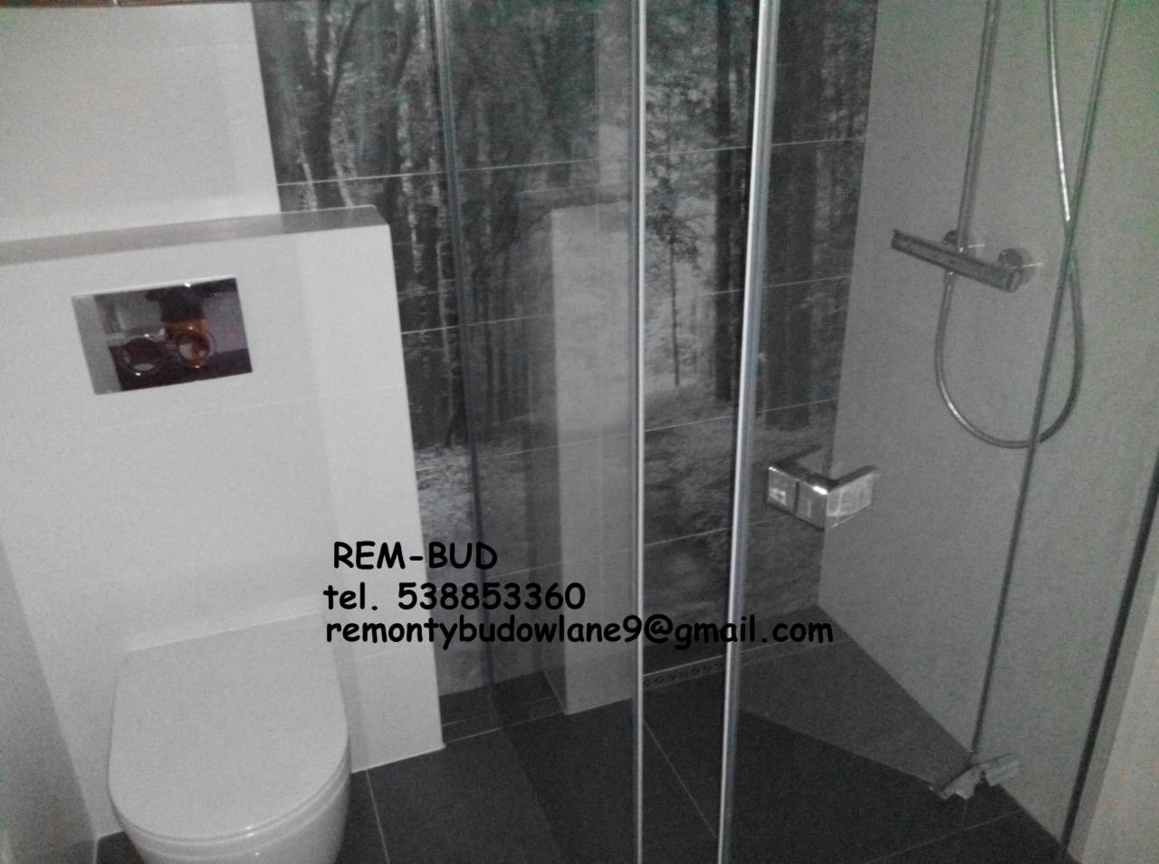 Nowoczesna łazienka z podwieszaną toaletą i kabiną prysznicową z motywem leśnym na płytkach, widoczny numer telefonu i adres e-mail firmy REM-BUD.