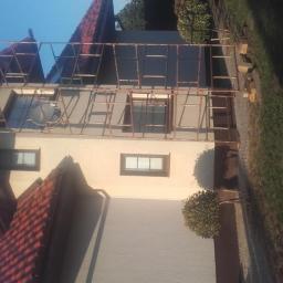 macedonska - Dom jednorodzinny z nałożonym rusztowaniem podczas prac remontowych, widoczne świeżo pomalowane elewacje w odcieniach beżu i szarości.