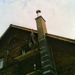 Mur z cegły z rusztowaniem i kominem z elementami szalunkowymi, widok z dołu.