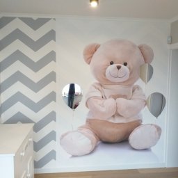 Elba - Pokój dziecięcy z pomalowaną ścianą w biało-szare zygzaki i fototapetą przedstawiającą pluszowego misia z balonami, biała komoda z szufladami z lewej strony