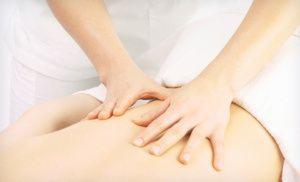 Dłonie wykonujące ruchy ugniatające na plecach pacjenta leżącego na białym prześcieradle, usługa dostępna w Mosinie.